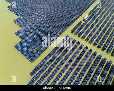 Vue aérienne du parc solaire de Sirajganj de 68 MW présentant des rangées de panneaux photovoltaïques installés sur l'eau à Sirajganj, division de Rajshahi, Bangladesh. Banque D'Images