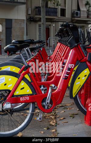 Barcelone, Espagne — Des vélos rouges du système de partage public Bicing alignés à une station d’accueil dans une rue urbaine. Les vélos de location de marque illustrent le partage Banque D'Images