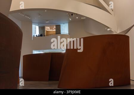 Les visiteurs admirent l'installation « The Matter of Time » de Richard Serra depuis une passerelle du musée Guggenheim à Bilbao, en Espagne. Banque D'Images