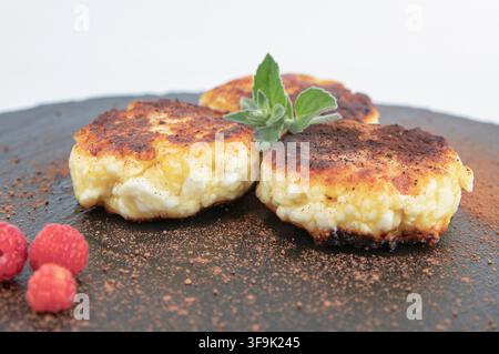Crêpes au fromage blanc maison servies avec des framboises, du cacao et des herbes fraîches Banque D'Images