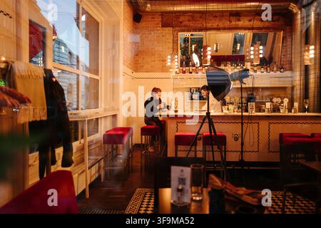 Intérieur de café douillet avec un éclairage chaleureux, des sièges de bar et un design de restaurant moderne Banque D'Images