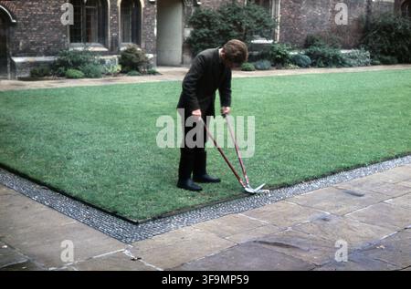 Cambridge, Angleterre, - 1er septembre 1965 : un étudiant tond la pelouse dans la cour du Queens College de Cambridge Banque D'Images