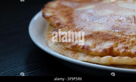 Crêpes empilées dans une assiette blanche Banque D'Images