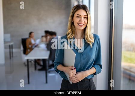 Heureux hommes d'affaires multiethniques riant tout en collaborant à un nouveau projet dans un bureau. Banque D'Images