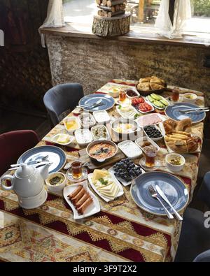 Répandu de petit-déjeuner turc riche et coloré mettant en vedette diverses spécialités locales, servi sur une table décorée dans un cadre confortable Banque D'Images