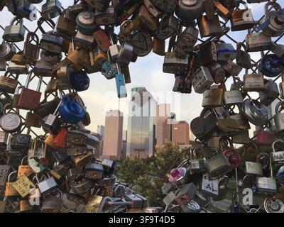 Locks of Love sur une clôture avec les bâtiments du centre-ville de Houston au coucher du soleil. Banque D'Images