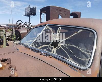 Paroi vitrée fissurée sur une vieille voiture rouillée, décharge le long de la Route 66, Moriarty, NM. Banque D'Images
