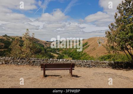 Un banc en bois vide face à la vue panoramique pittoresque de la vallée de Monsal Dale depuis Monsal Head, Parc national du Peak District, Derbyshire, Royaume-Uni. Banque D'Images