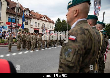 Les soldats du 2e bataillon, 37e régiment blindé, des Light Dragoons de l'armée britannique, du 17e contingent croate et du 348e bataillon d'artillerie de défense aérienne roumaine, faisant partie du groupe de combat des forces terrestres avancées de l'OTAN-Pologne, se tiennent en formation avec les forces polonaises et allemandes lors d'un défilé pour la Journée des forces armées polonaises à Orzysz, en Pologne, le 16 août 2026, commémorant la victoire de la Pologne sur la Russie soviétique lors de la bataille de Varsovie de 1920. Banque D'Images