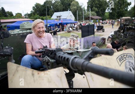 Soldat de première classe Rian Williams de l'U.S. Army, affecté au 2e bataillon, 37e régiment blindé, sourit avec un citoyen polonais lors d'une exposition statique pour la Journée des forces armées polonaises à Orzysz, en Pologne, le 16 août 2026, commémorant la victoire de la Pologne sur la Russie soviétique lors de la bataille de Varsovie de 1920. Banque D'Images