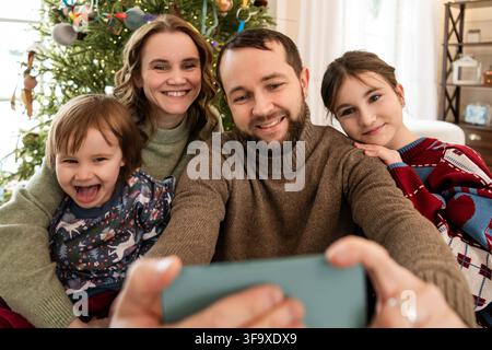 Famille heureuse prenant un selfie à Noël Banque D'Images