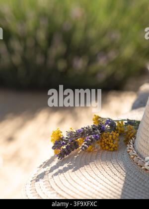 Fleurs fraîches de lavande et de tanaisie sur un chapeau de soleil tissé Banque D'Images