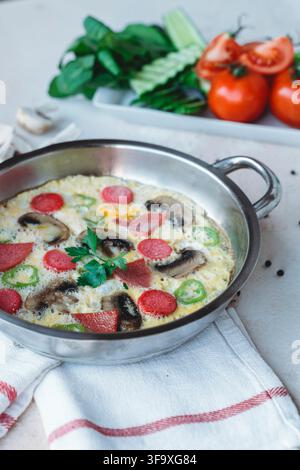 Omelette aux saucisses et aux champignons dans une poêle Banque D'Images