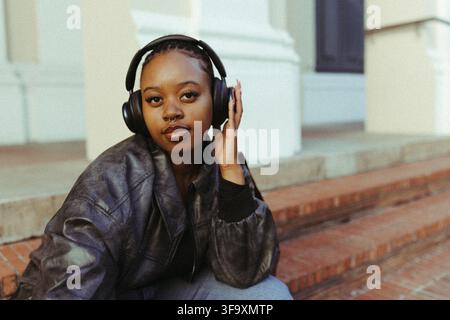 Jeune femme noire écoutant de la musique avec un casque Banque D'Images
