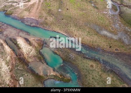 Sunamganj, Bangladesh - 26 août 2024 : Vue aérienne de la rivière Jadukata avec deux bateaux en bois sur l'eau, entourée de berges herbeuses et de bassins naturels Banque D'Images