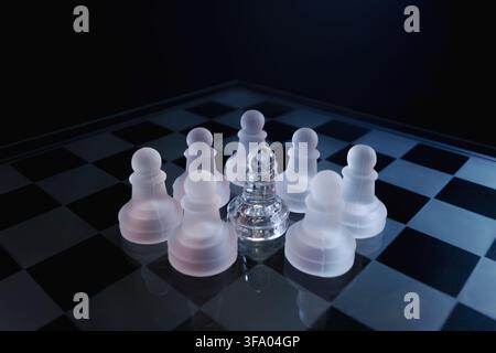 Jeu d'échecs dramatique en verre avec éclairage blanc symbolisant l'abus, l'oppression et l'intimidation. Banque D'Images
