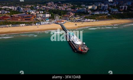 Vue aérienne du pier de Bournemouth s'étendant dans la mer avec la plage de sable, la grande roue et la ligne d'horizon de la ville en arrière-plan à Bournemouth, Banque D'Images