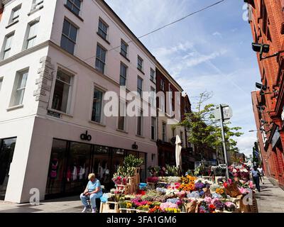 Dublin, Irlande – 22 mai 2026 : étalage de fleurs en plein air dans une rue de Dublin avec des bouquets colorés, des acheteurs et des devantures de magasins urbains. Banque D'Images