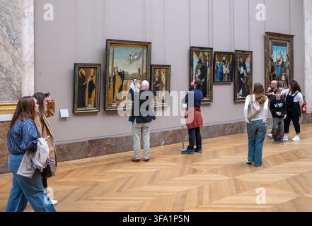 Visiteurs regardant les peintures au musée du Louvre à Paris, France Banque D'Images