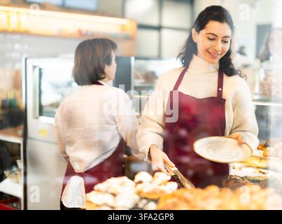 Fille vendeuse travaille dans la boutique de boulangerie cafétéria Banque D'Images