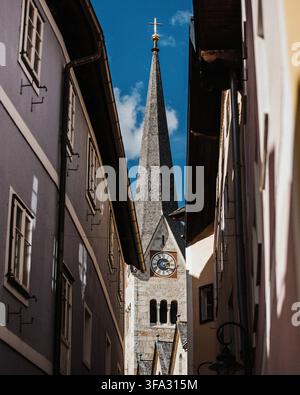 Vue du clocher de l'Église évangélique de Hallstatt encadré par des bâtiments historiques dans une ruelle étroite à Hallstatt, Haute-Autriche, Autriche. Banque D'Images