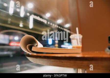 Livre ouvert avec une page recourbée reposant sur une table en bois dans un café confortable à Bangkok, Thaïlande — Banque D'Images