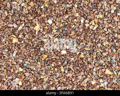 Texture de fond en vue supérieure de pierres de gravier broyées fines brunes et rouges. Banque D'Images