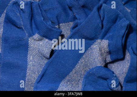 Une photographie macro montrant une vue rapprochée et détaillée de la texture tricotée et des côtes des plusieurs chaussettes bleues arborant une pa blanche contrastante Banque D'Images