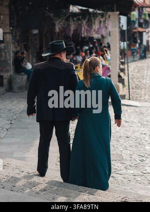 Couple marchant main dans la main sur une rue pavée à Huasca de Ocampo Banque D'Images