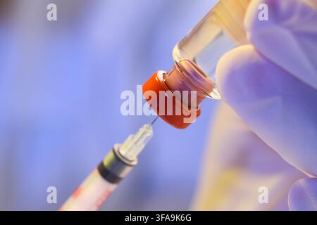 Développement de vaccins et recherche médicale, main gantée remplissant une seringue à partir d’un flacon pour injection, soins de santé et industrie pharmaceutique Banque D'Images