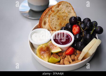 Assiette de petit-déjeuner avec fruits, noix et pain Banque D'Images