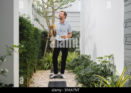 Homme reposant paisiblement sur un canapé dans un espace de vie moderne et confortable, moment de calme et personnel. Banque D'Images
