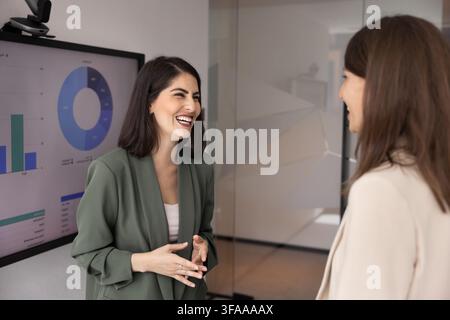 Collègues femmes d'affaires heureuses profitant d'une conversation amicale informelle dans une entreprise technologique Banque D'Images