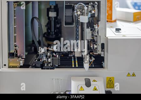 Analyseur de laboratoire automatisé avec système de pipettage robotisé. L'analyseur de laboratoire ouvert révèle les composants de pipettage robotisé, les moteurs, le câblage et l'échantillon Banque D'Images