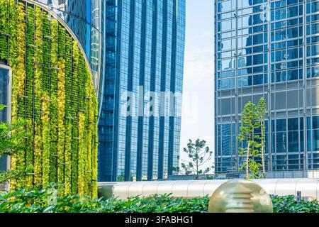 Jardin vertical sur une architecture moderne en verre dans la ville de Hong Kong. Intégration de la végétation dans le quartier des affaires, développement durable, urbain Banque D'Images