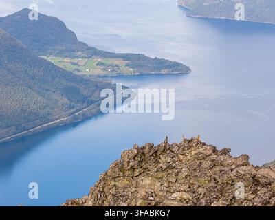Vue aérienne du sommet Kongen surplombant les eaux bleu profond du fjord de Romsdal avec un terrain rocheux accidenté et des pentes verdoyantes à Andalsnes, Møre et Romsdal Banque D'Images