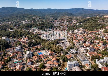 Panorama aérien par drone de Vrnjačka Banja, Serbie, photographié le 15 août 2026. L'image montre la ville thermale entourée de collines boisées et de verts pré Banque D'Images