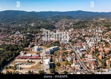 Panorama aérien par drone de Vrnjačka Banja, Serbie, photographié le 15 août 2026. L'image montre la ville thermale entourée de collines boisées et de verts pré Banque D'Images