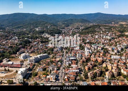 Panorama aérien par drone de Vrnjačka Banja, Serbie, photographié le 15 août 2026. L'image montre la ville thermale entourée de collines boisées et de verts pré Banque D'Images