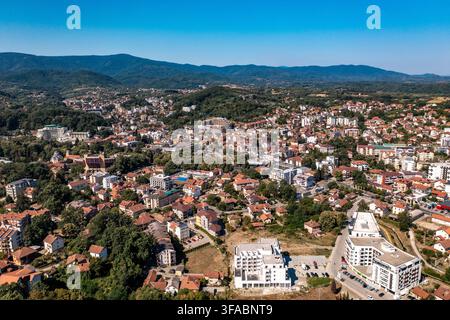 Panorama aérien par drone de Vrnjačka Banja, Serbie, photographié le 15 août 2026. L'image montre la ville thermale entourée de collines boisées et de verts pré Banque D'Images