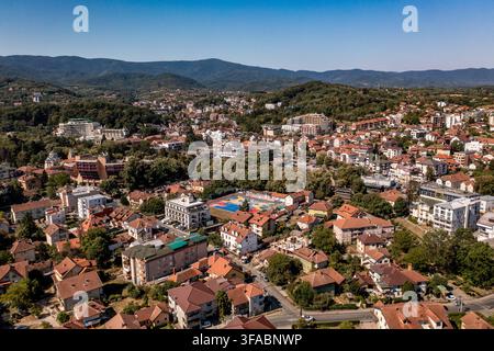 Panorama aérien par drone de Vrnjačka Banja, Serbie, photographié le 15 août 2026. L'image montre la ville thermale entourée de collines boisées et de verts pré Banque D'Images