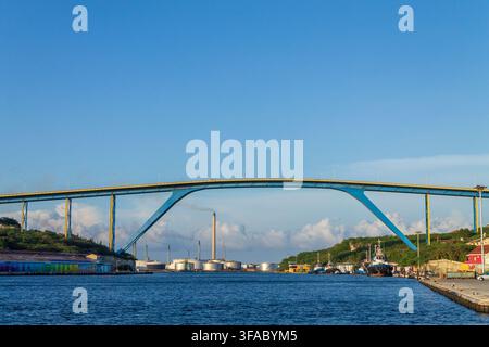 Willemstad, Curaçao, Curaçao - 08 novembre 2014 : Vue du pont de la reine Juliana enjambant le port avec des réservoirs de stockage industriels et un ciel bleu dans le ba Banque D'Images