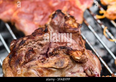 Close-up détaillé de viande d'agneau rôtie savoureuse cuisant sur une grille métallique de barbecue au-dessus d'un charbon de bois chaud avec une texture grillée juteuse préparée pour un repas délicieux Banque D'Images