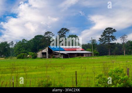 Grange avec un drapeau du Texas peint sur le toit en tôle dans la campagne du Texas sous un ciel dramatique Banque D'Images