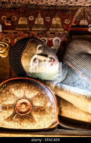 Close-up d'une tête de Bouddha allongée sur un coussin dans la grotte 3 des temples historiques de Dambulla, construits sous un énorme surplomb rocheux au Sri Lanka Banque D'Images