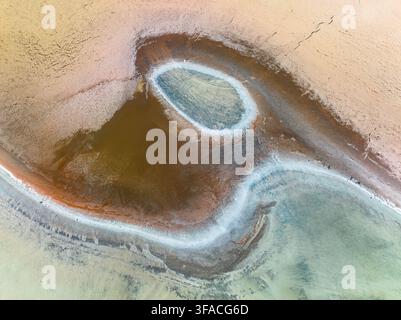 Vue aérienne du lac salé près de Pithara, présentant des motifs complexes de dépôts minéraux, une terre sèche et craquelée et des étangs d'eau peu profonds à Pithara Banque D'Images