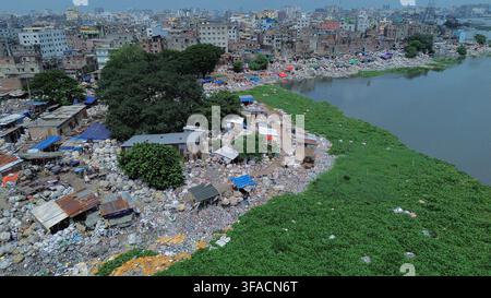 Une vue aérienne montre une zone informelle de recyclage des déchets plastiques bordant les rives de la rivière Buriganga dans la région de Sadarghat à Dhaka, au Bangladesh, le 19 août 2026. Des quantités considérables de plastique collecté sont triées et traitées dans des cours densément remplies, tandis que les déchets non recyclables sont fréquemment jetés dans la rivière. La pression croissante des déchets urbains et industriels pollue gravement et rétrécit la voie d'eau, menaçant l'écosystème, la santé publique et les moyens de subsistance des communautés dépendantes de la rivière. Photo par Habibur Rahman/ABACAPRESS.COM Banque D'Images