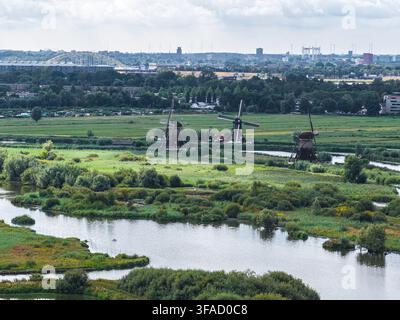 Vue aérienne des moulins à vent historiques de Kinderdijk entourés de zones humides luxuriantes, de canaux sinueux et d'arbres à Kinderdijk, Zuid-Holland, Pays-Bas Banque D'Images