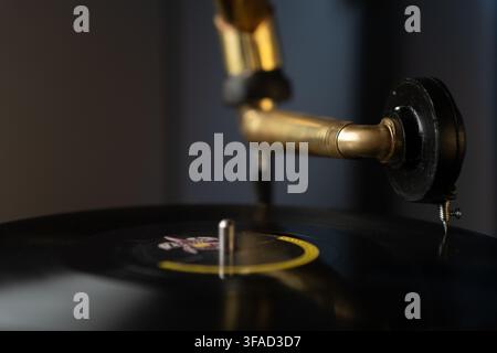 Plan rapproché horizontal d'un bras de tonneau en laiton et d'une aiguille reposant sur un vinyle, avec espace de copie, éclairage de studio à faible clé et lisse Banque D'Images