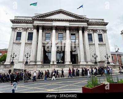 Dublin, Irlande - 22 mai 2026 : Un grand groupe d'étudiants et de piétons passe devant une mairie néoclassique à Dublin, en Irlande. Banque D'Images